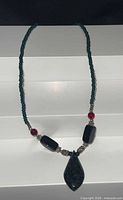 full view of necklace showing bead arrangement and pendant