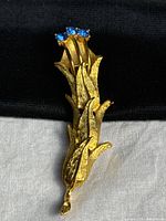 Front view showing full floral brooch and blue rhinestones