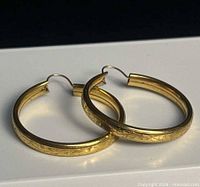 earrings angled showing etched detail on outer edge