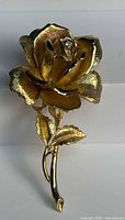 Front view of gold-tone rose brooch