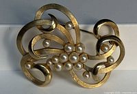 Front view showing full swirl design and pearl cluster