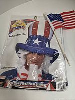 Front of sealed package showing inflatable hat and included flag