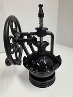 Angled view showing hopper, gears, wheel and wooden handle