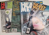 Five Heavy Metal magazines overlapped showing distinct cover colors and logos