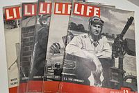 Five WWII-era Life magazines fanned to show each cover