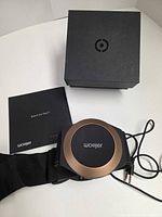 Woojer Haptic Strap with belt, booklet and retail box on table