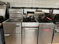 Front view of stainless steel double-well fryer with baskets inserted