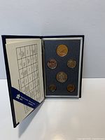Case opened showing six coins and specifications card
