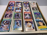 Open three-row card box showing mixed era baseball cards and sample star/player cards on top