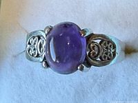 Top view showing oval amethyst cabochon and scroll shoulders