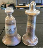 Front view of both sand-filled glass bottles showing shapes and colour layers