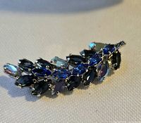 front view of silver-tone brooch showing blue navette rhinestones