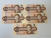 Obverse of five $2 notes showing Queen portrait and denominations