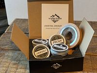 Open box showing smoker lid, two wood chip tins, booklet and packaging