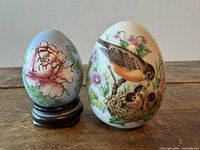 Front view of both porcelain eggs showing bird and floral designs