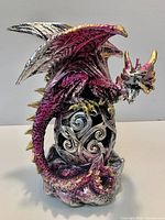Full view of metallic magenta, silver and gold resin dragon figurine