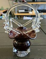 Full view of burgundy glass basket showing handle, ruffled clear glass accents, and base