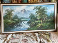 Full view of framed landscape painting showing mountain, stream, trees and frame