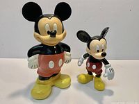 Front view of both Mickey Mouse plastic figurines