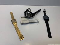 Three watches laid out side by side on surface