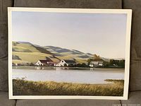 Example print depicting farm buildings beside a lake with hills in background
