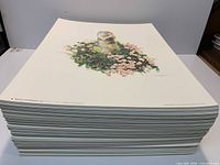 Stack of lithograph prints showing uniform artwork and paper size