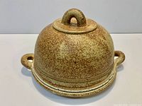 Butter dish assembled showing exterior brown speckled glaze and lid with loop handle
