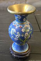 Full view of cloisonné vase on stand showing floral design and brass rim