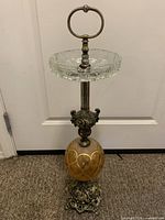 Full view of standing ashtray showing glass dish, column, amber orb and base