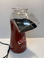 Full view of red West Bend Air Crazy popcorn popper with clear chute and power cord