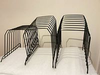Front/side view of three black metal file holders showing slot structure