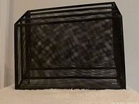 Angled view of black metal mesh 3-tier letter sorter showing mesh construction