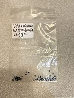 Plastic bag with label showing loose round blue sapphires