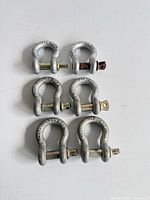 Six galvanized bow shackles laid out