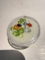 Jar containing mixed loose gemstones viewed from above