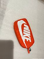 Top view showing white Nike logo on orange pouch