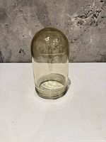 Full view of smoky amber glass cloche dome standing upright