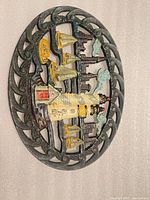 Front view of painted cast iron lighthouse trivet showing full nautical scene