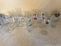 All 17 beer glasses lined up to show variety and logos