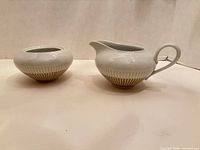 Creamer and sugar bowl showing matching design