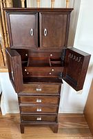 Front view of jewelry armoire open showing drawers and side doors