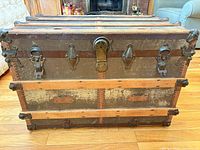 Front view of closed trunk showing wood slats, metal banding, latches, lock