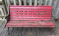 Full front view of red slat garden bench