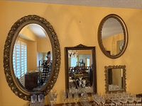 Wall view showing three ornate gold mirrors