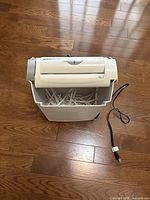 Shredder with bin and power cord visible