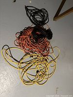 Pile of four extension cords in yellow, orange and black colours