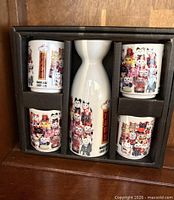 Full boxed set showing flask and four cups