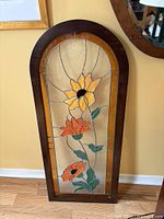Full view of arched stained glass panel in wood frame