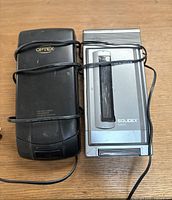 Top view of two VHS tape rewinders showing Optex and Solidex branding