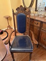 Full view of one chair showing wood frame, upholstery, arms, legs